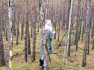 A blonde European woman performs oral sex on a smelly uncut cock in a forest setting