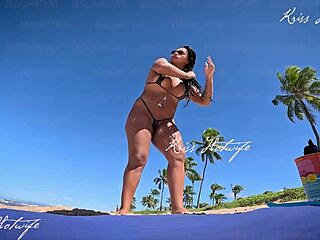 Tanned brunette flaunts micro bikini on beach