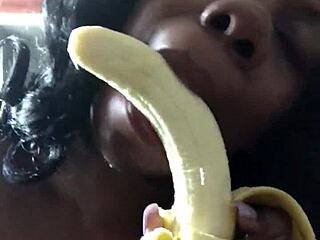 Black mama eats a banana like it is an orange
