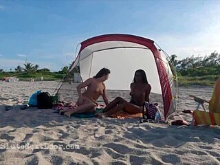 DOUBLE HANDJOB rocks public beach scene!