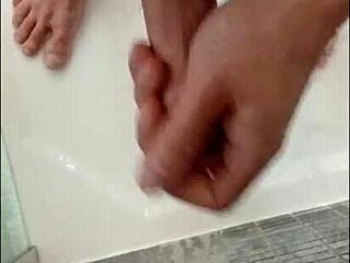 I'm showering my hard cock in the bathroom, feeling the water cascade over my muscular bodybuilder frame with blue eyes.